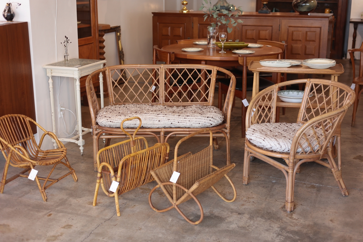 ラタンの2人掛けソファやチェア、マガジンラックが並ぶ